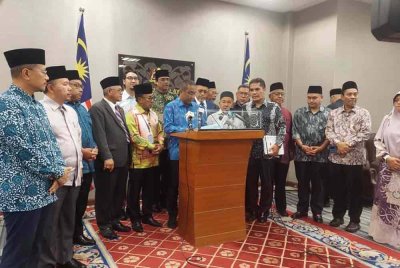 Takiyuddin (depan, enam dari kiri) dan Shahidan (depan, tujuh dari kiri) bersama ahli Parlimen PN semasa sidang akhbar pada Khamis.