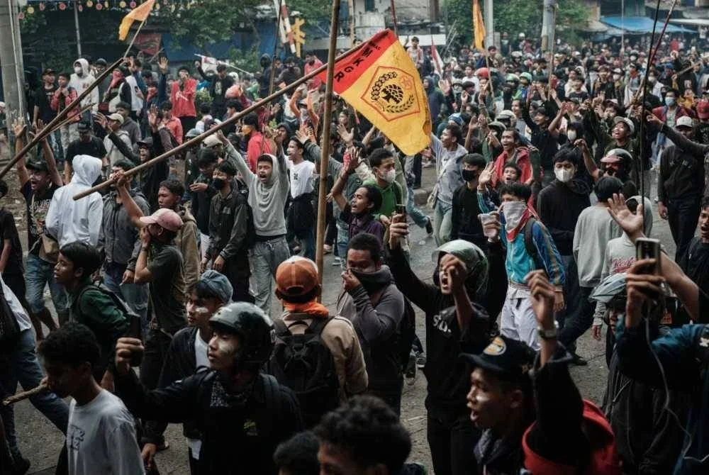 Penunjuk perasaan berhimpun dalam protes kesatuan pekerja menuntut penambahbaikan syarat kerja berhampiran Parlimen di Jakarta. - AFP