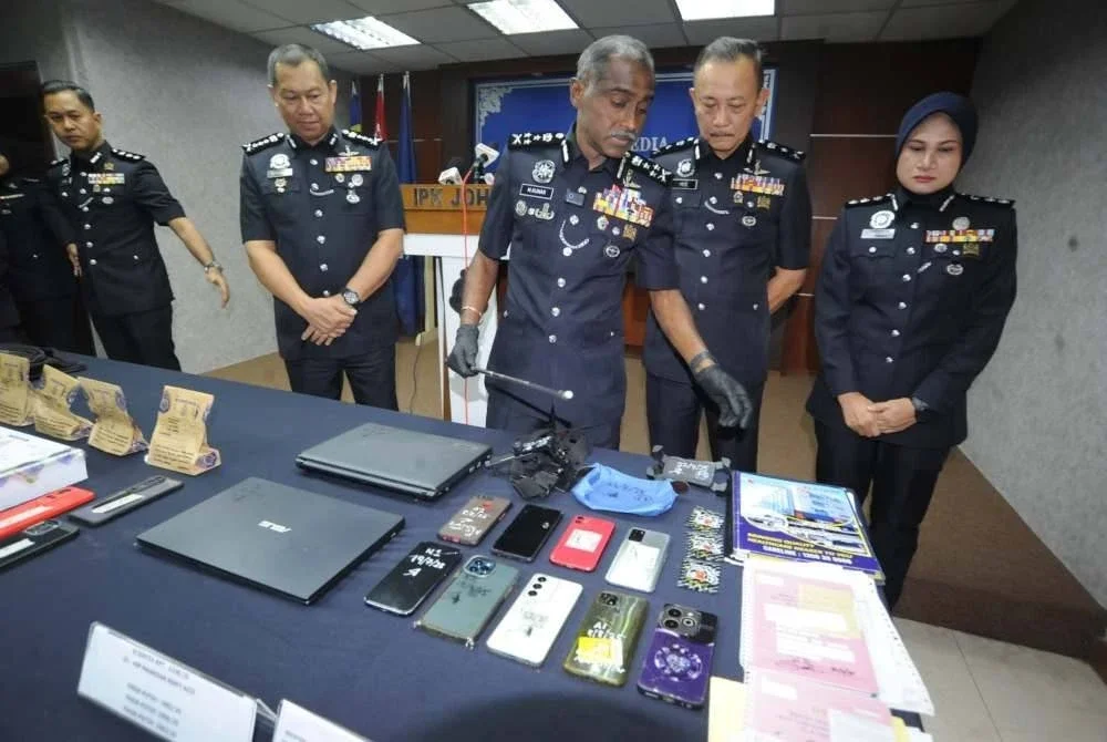 M Kumar melihat dokumen kelahiran bayi dan barangan yang dirampas daripada sindiket pedofilia pada sidang akhbar di IPK Johor pada Jumaat.