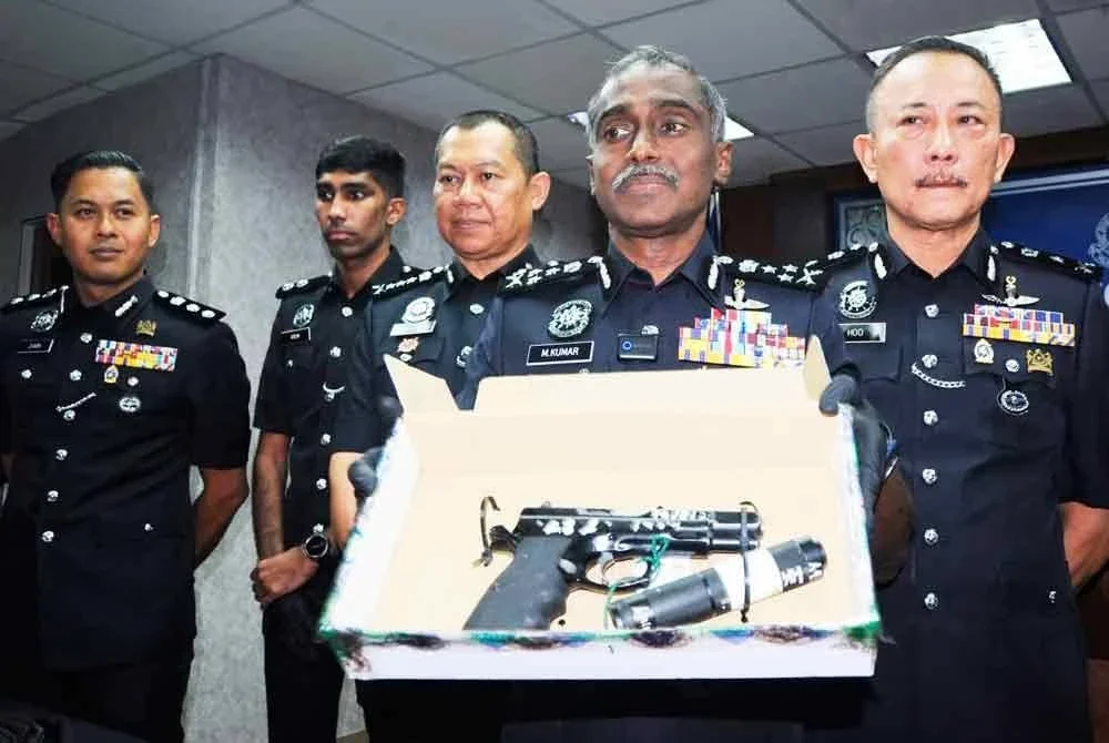 M Kumar menunjukkan pistol yang dirampas daripada suspek.
