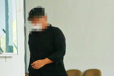 Tertuduh berbaju hitam ketika hadir ke mahkamah