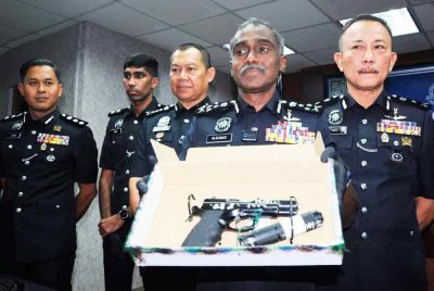 M Kumar menunjukkan pistol yang dirampas daripada suspek.