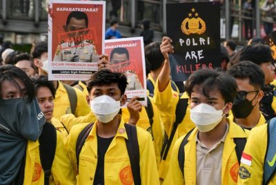 Peserta protes membawa poster tertera 'individu dikehendaki' memaparkan wajah Ketua Polis Nasional, Jeneral Listyo Sigit Prabowo ketika demonstrasi di hadapan ibu pejabat polis di Jakarta pada Jumaat. - Foto AFP