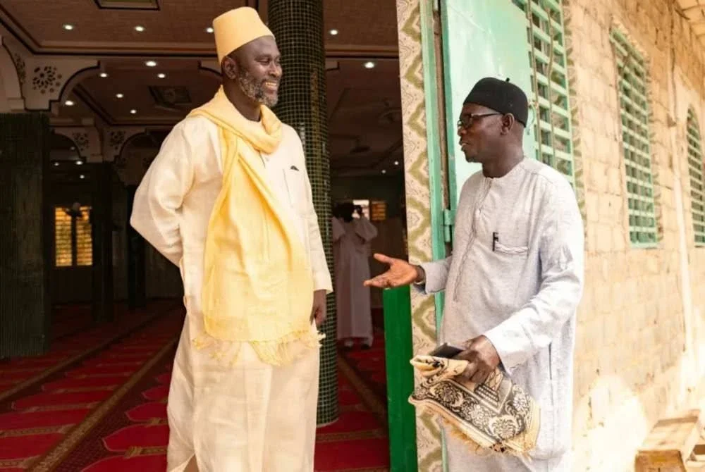 Imam Ibrahima Diane (kiri) berbincang dengan penyelaras 'sekolah untuk suami', El Hadj Malick.