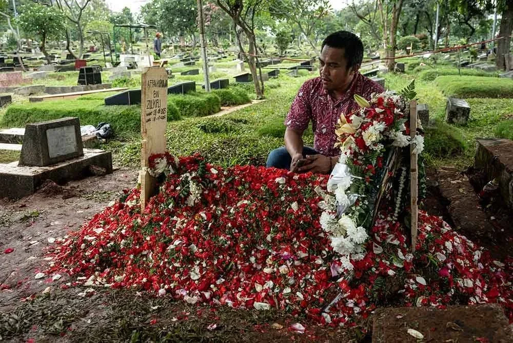 Seorang rakan berdoa di pusara Affan Kurniawan di Jakarta. Foto AFP