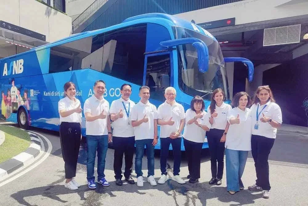 Fadzihan (empat dari kiri) mengiringi Pengerusi Kumpulan PNB, Raja Tan Sri Arshad Raja Tun Uda (lima dari kanan) bergambar semasa Pelancaran Bas ASNB GO di Merdeka Boulevard 118 di sini pada Sabtu.