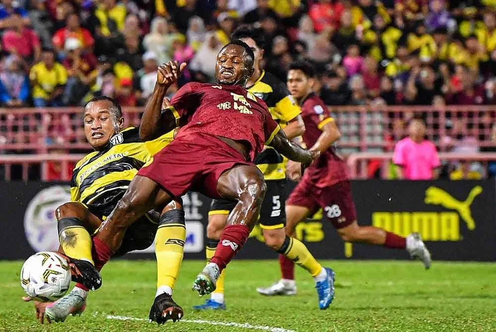 Esso (tengah) bersaing dengan pemain Rodney dalam aksi Liga Super di Stadium Tuanku Abdul Rahman, Paroi.