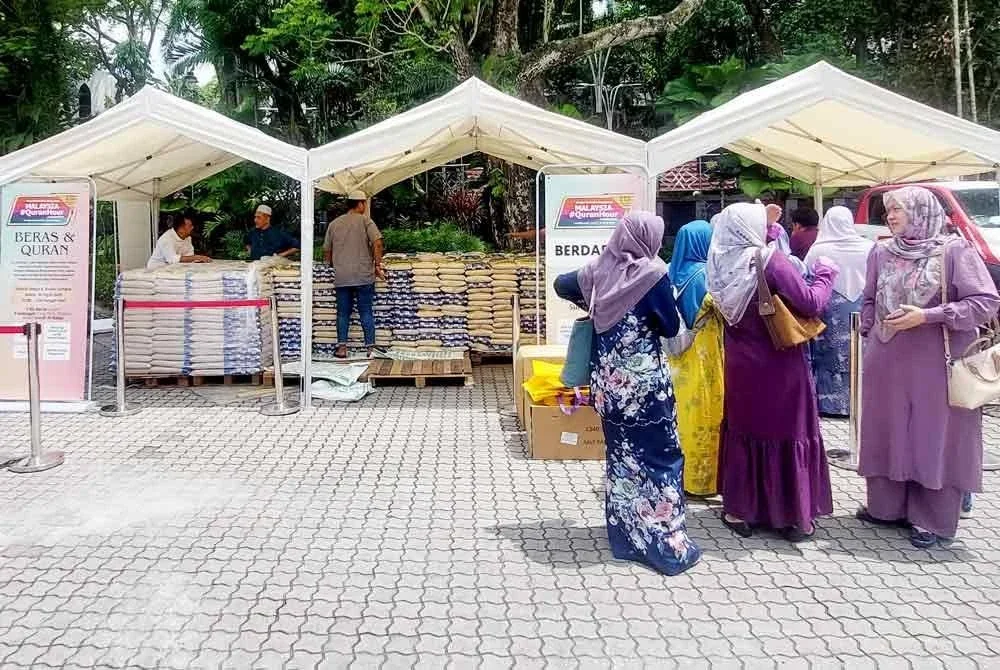 Penerima dilihat sedang beratur di khemah penyerahan sumbangan beras Masjid Negara pada Sabtu.