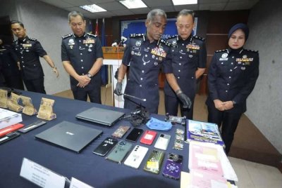 M Kumar melihat dokumen kelahiran bayi dan barangan yang dirampas daripada sindiket pedofilia pada sidang akhbar di IPK Johor pada Jumaat.