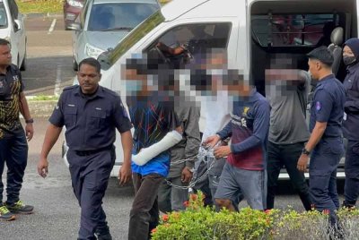 Suspek kelihatan tenang ketika tiba di pekarangan mahkamah pada jam 9.13 pagi diiringi anggota polis. Foto Astro AWANI
