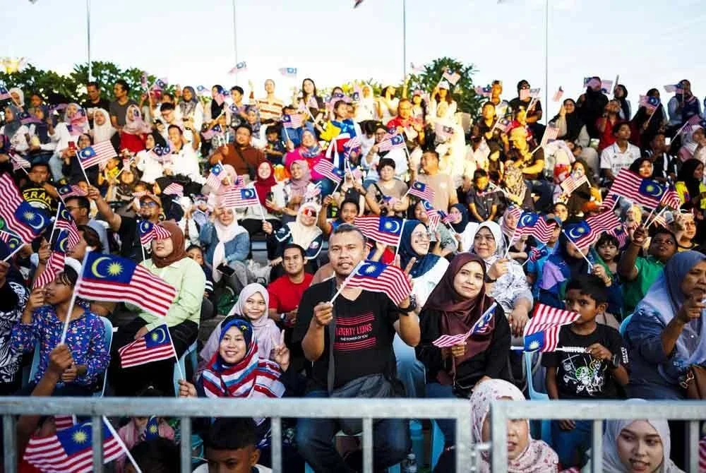 Pengunjung mengibarkan Jalur Gemilang pada Sambutan Hari Kebangsaan Peringkat Negeri Perak 2025 di Bangunan Bandaran Ipoh hari ini. Foto Bernama