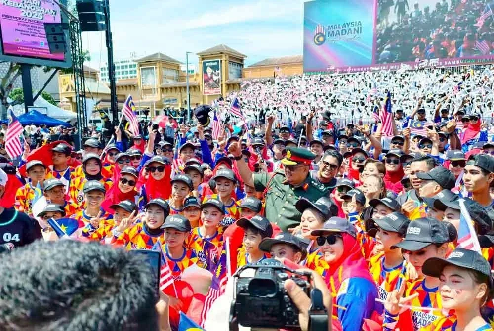 Ab Rauf ( tengah) bersama dengan sebahagian pelajar yang menyertai persembahan grafik manusia pada sambutan Hari Kebangsaan Peringkat Negeri di Jalan Merdeka, Banda Hilir pada Ahad.