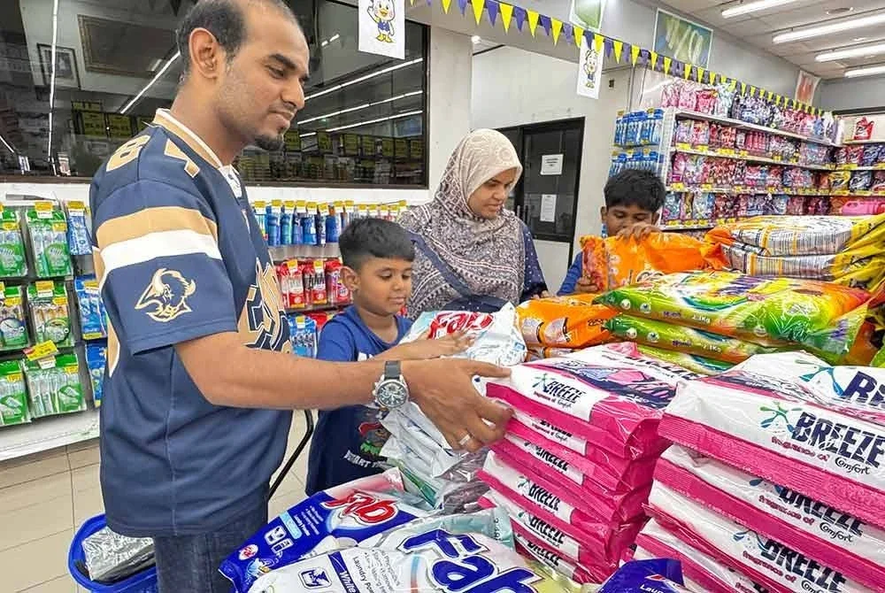 Nur Baini dan keluarga memilih barangan keperluan untuk dibeli.