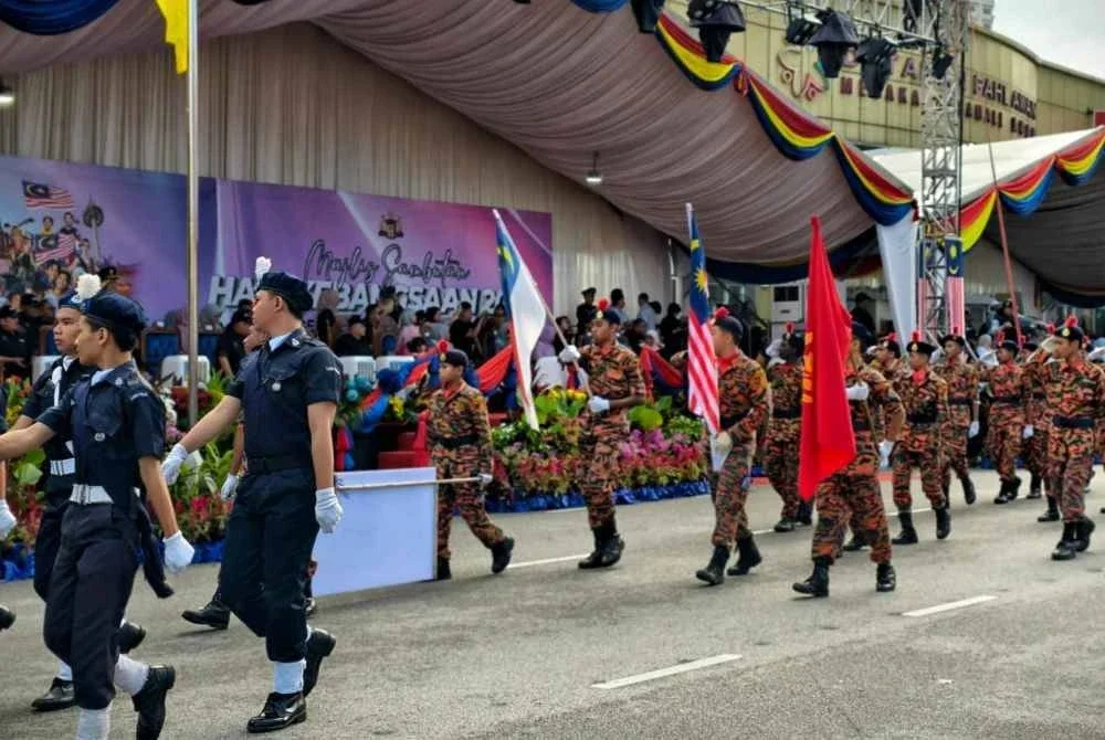 Perserta perbarisan melakukan lintas hormat ketika melalui pentas utama pada sambutan Hari Kebangsaan 2025 di Jalan Merdeka, Banda Hilir Melaka pada Ahad.
