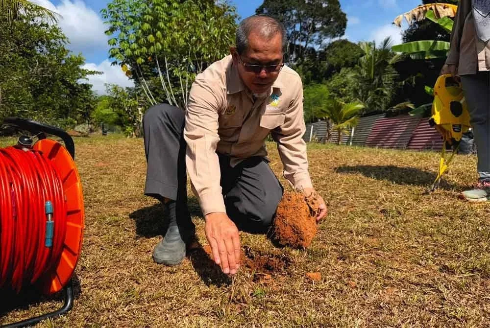 Mohd Nur Asmawisham menggunakan ABEM Terrameter LS 2 untuk melihat keadaan struktur di bawah tanah di lokasi rekahan tanah kebun di Jalan Buloh Kasap, Batu 2, pada Ahad. Foto Bernama