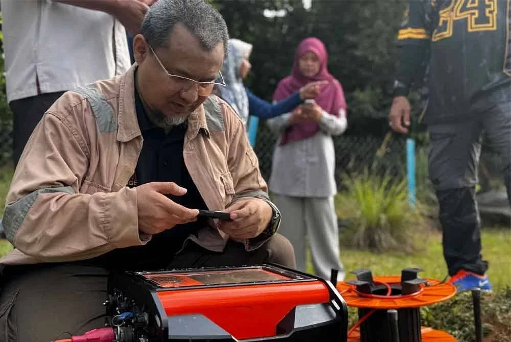 Mohd Nur Asmawisham menggunakan peralatan teknologi ABEM Terrameter LS 2 iaitu sistem rintangan (resistivity) untuk melihat keadaan struktur di bawah tanah. Foto Bernama