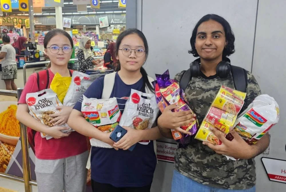 Nawitashini (kanan) bersama dua lagi rakannya teruja pertama kali menggunakan bantuan SARA RM100 bagi membeli makanan dan alat tulis.