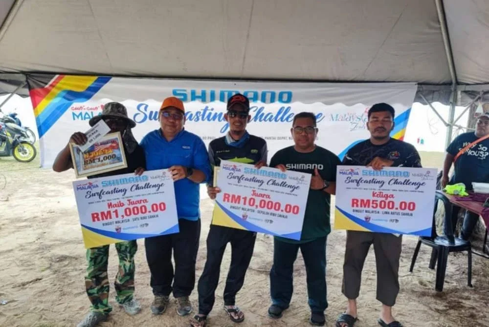 Ismail (dua dari kanan) menyampaikan hadiah kepada pemenang pertandingan Shimano Surfcasting di Pantai Sepat, Kuantan pada Ahad.