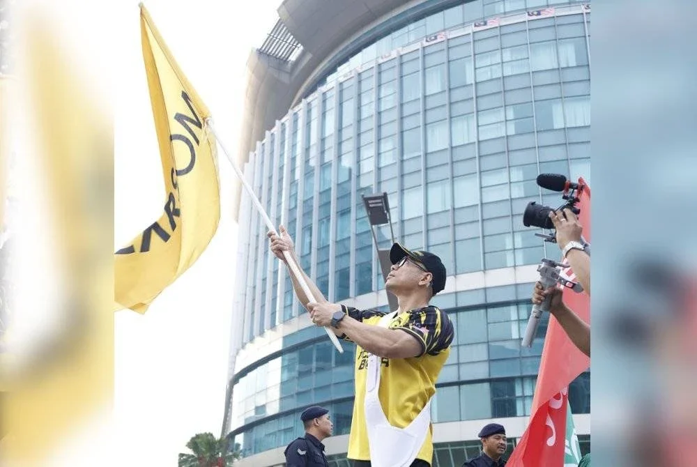 Kontinjen CARSOME diketuai Mohd Afifi Zahari yang membawa bendera syarikat dalam perarakan tersebut.