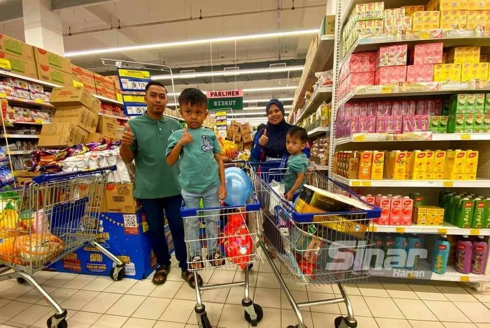 Mohamad Khairizai, isteri dan anak-anak bersama barangan yang dibeli mereka di Pasar Raya Mydin Tunjung, Kota Bharu pada Ahad.