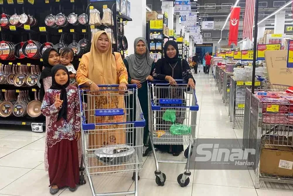 Siti Mastura (kanan) dan keluarga dari Jerteh, Terengganu tidak melepaskan peluang menebus bantuan SARA di Pasar Raya Mydin Tunjung, Kota Bharu pada Ahad.
