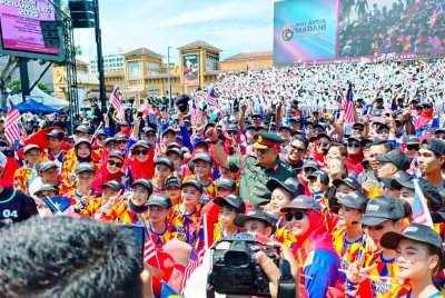 Ab Rauf ( tengah) bersama dengan sebahagian pelajar yang menyertai persembahan grafik manusia pada sambutan Hari Kebangsaan Peringkat Negeri di Jalan Merdeka, Banda Hilir pada Ahad.