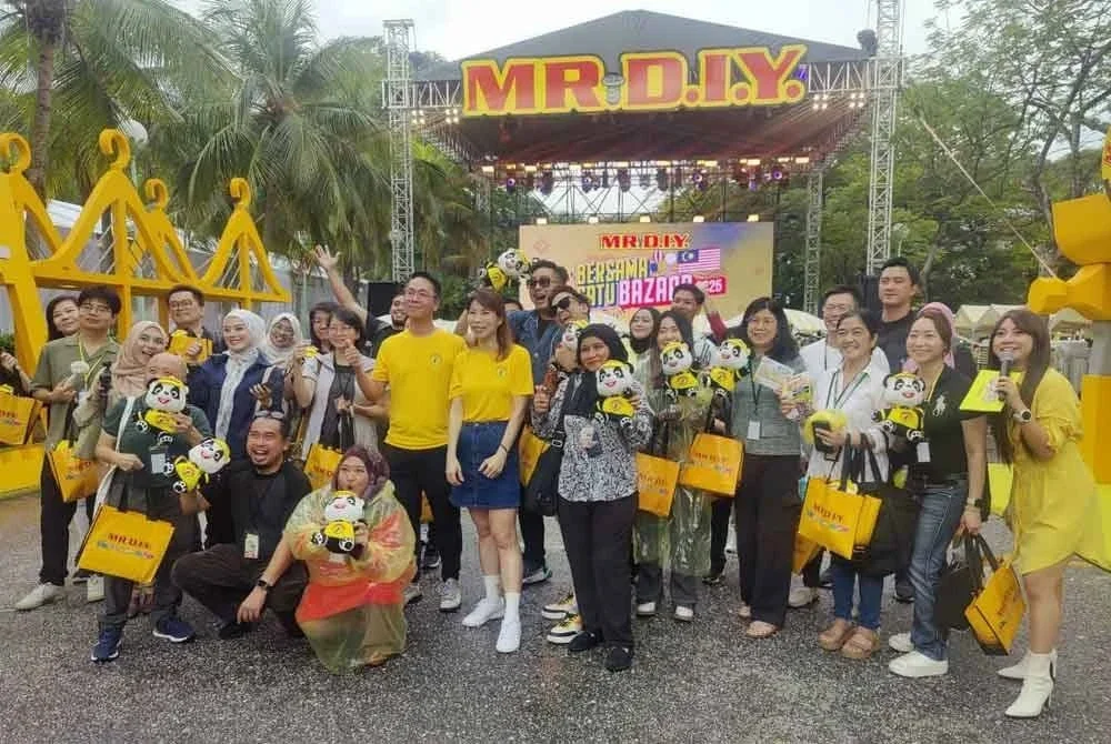 Alex (depan) bergambar bersama-sama petugas D.I.Y dan media pada Bersama Satu Bazaar di Tempat Letak Kereta Terbuka Sunway Pyramid di Subang Jaya pada Jumaat.