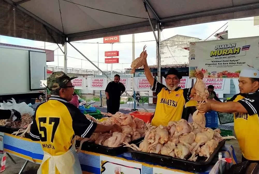 Syed Abu Hussin menunjukkan ayam segar yang dijual pada harga RM8 seekor sempena program Jualan Termurah Madani Sempena Kemerdekaan di Pusat Khidmat Ahli Parlimen Bukit Gantang pada Isnin.