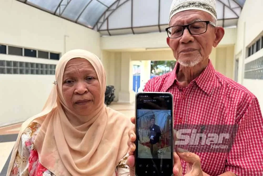 Ruhani (kiri) dan Wan Abdul Rahman (kanan) menunjukkan gambar Allahyarham Wan Ahmad Faris. Foto SINAR HARIAN - ADILA SHARINNI WAHID
