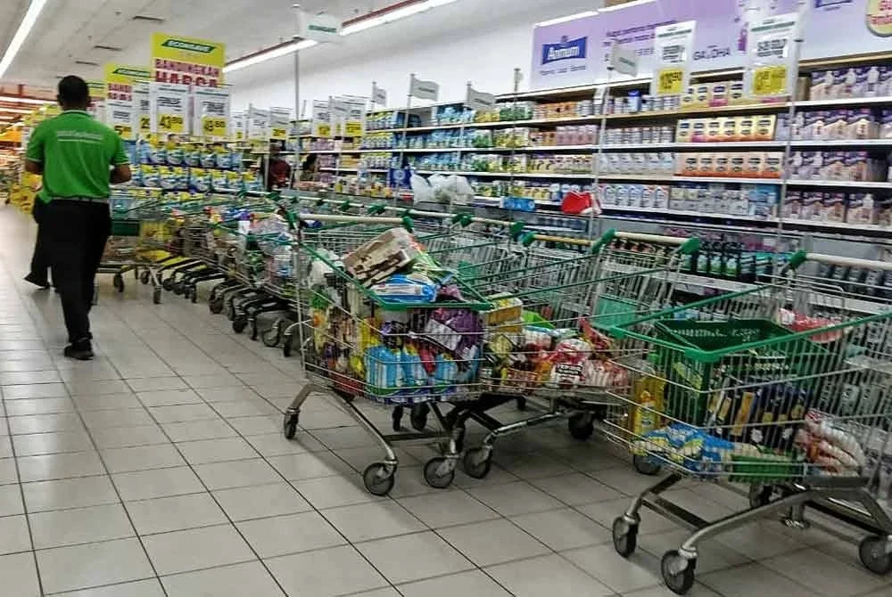 Pekerja pasar raya sedang mengasingkan lebih 10 troli berisi barangan yang didakwa ditinggalkan pengguna kerana bukan kategori produk terpilih.