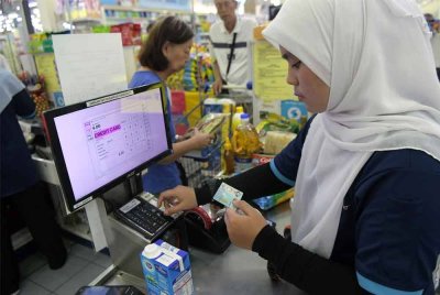 Juruwang melakukan semakan bantuan RM100 di dalam MyKad ketika tinjauan di Pasaraya TF Value Mart pada Ahad. Foto Bernama