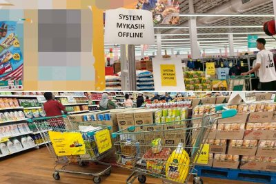 Orang ramai meninggalkan troli selepas pihak pasar raya mengumumkan sistem MyKasih tergendala.