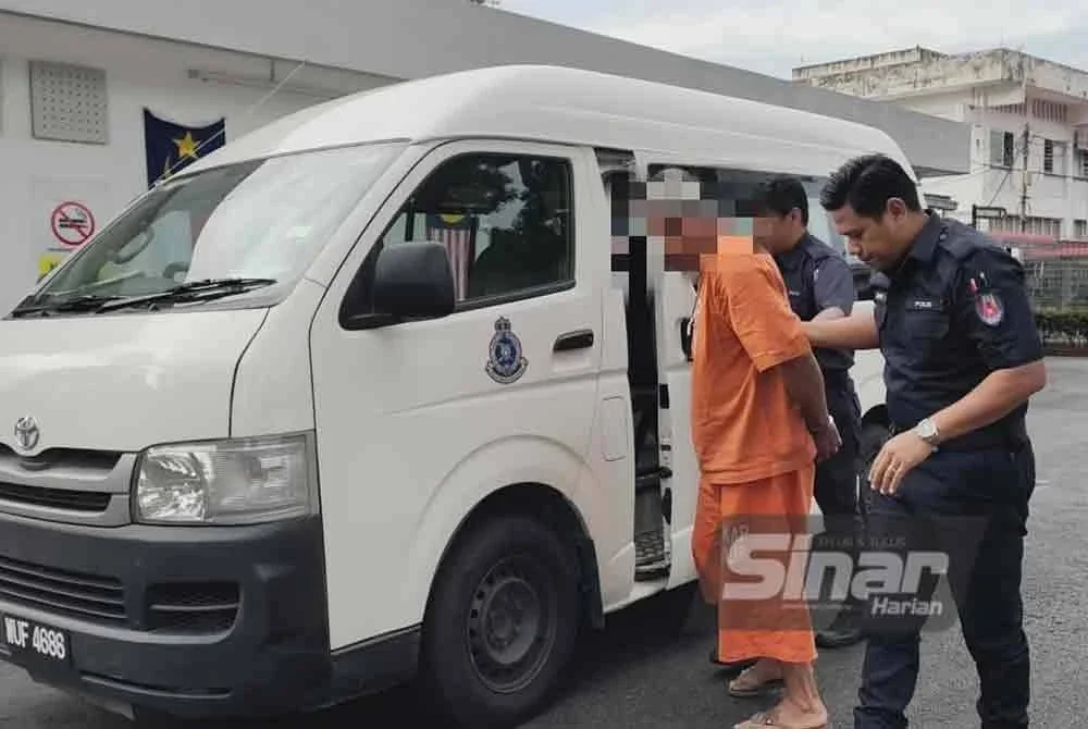 Suspek (tengah) dibawa ke Mahkamah Majistret Jasin pada Selasa.