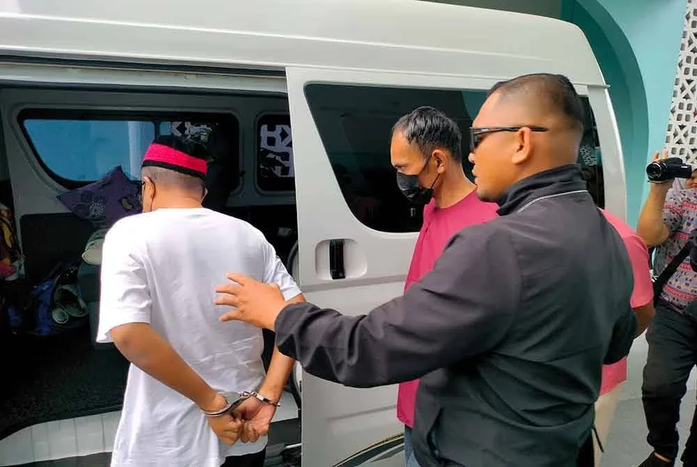 Muhammad Suhail (kiri) dan Azman (kanan) dibawa keluar dari Mahkamah Syariah Batu Pahat.