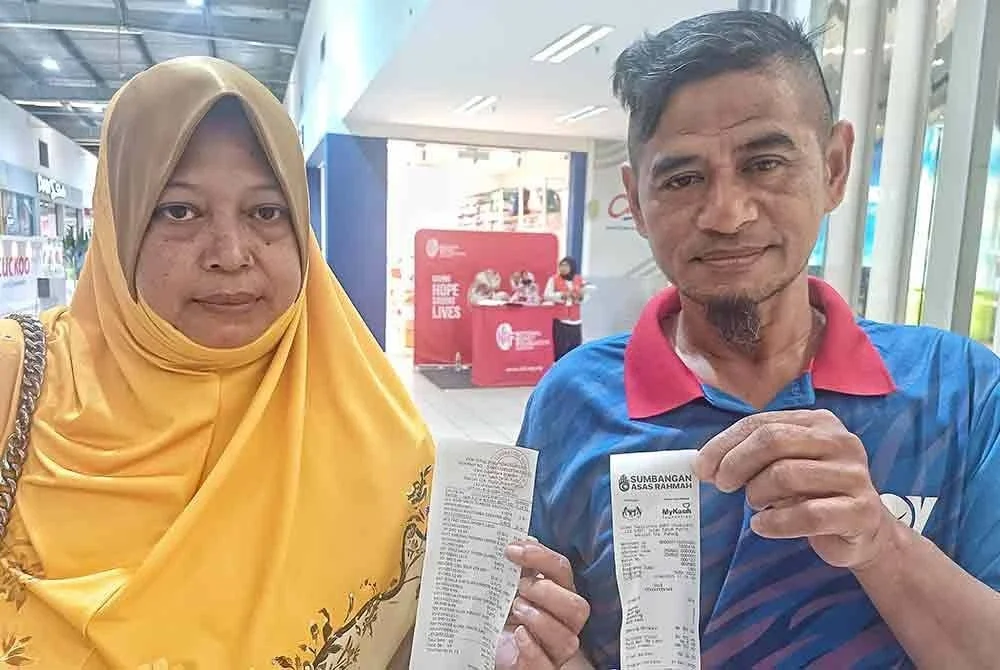 Safari dan isteri menunjukkan resit penebusan SARA yang berjaya ketika ditemui Sinar Harian di sebuah pasaraya pada Selasa.Foto Sinar Harian.