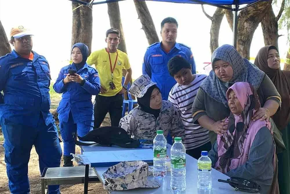 Che Bunga (kanan) yang bersedih dan ditenangkan oleh ahli keluarganya.