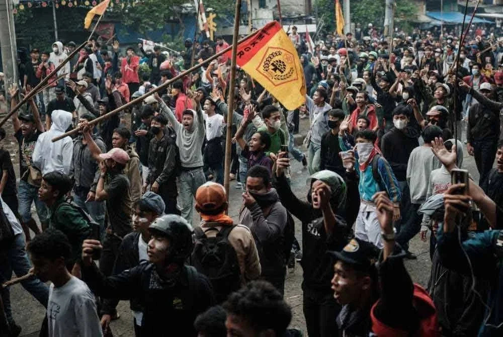 Penunjuk perasaan berhimpun dalam protes kesatuan pekerja menuntut penambahbaikan syarat kerja berhampiran Parlimen di Jakarta. - AFP