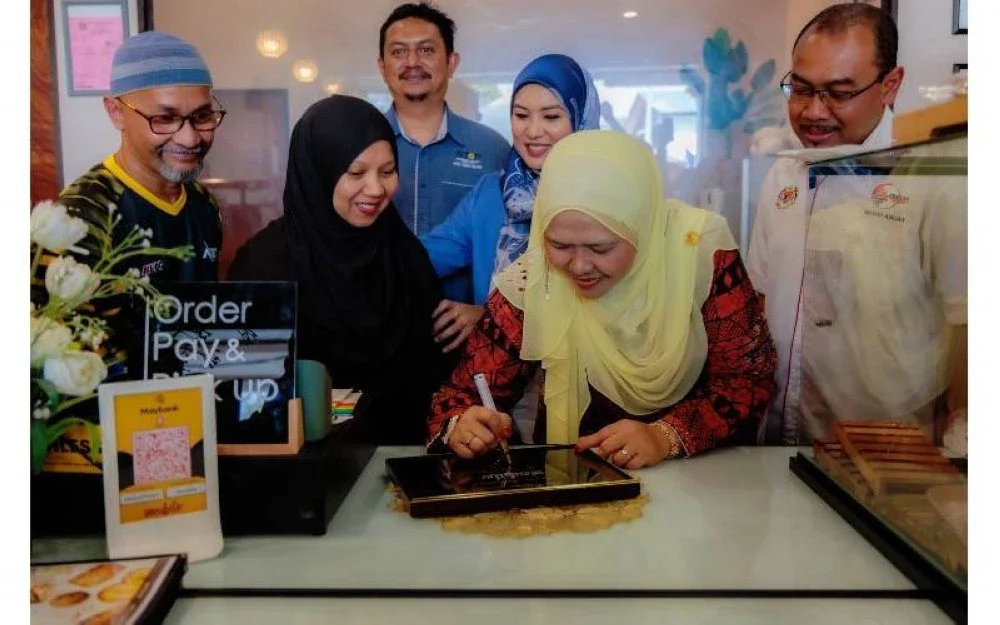 Salbiah (dua dari kanan) menandatangani plak sebagai gimik perasmian Kafe Secubite yang diadakan di Kafe Secubite, di Ipoh baru-baru ini.