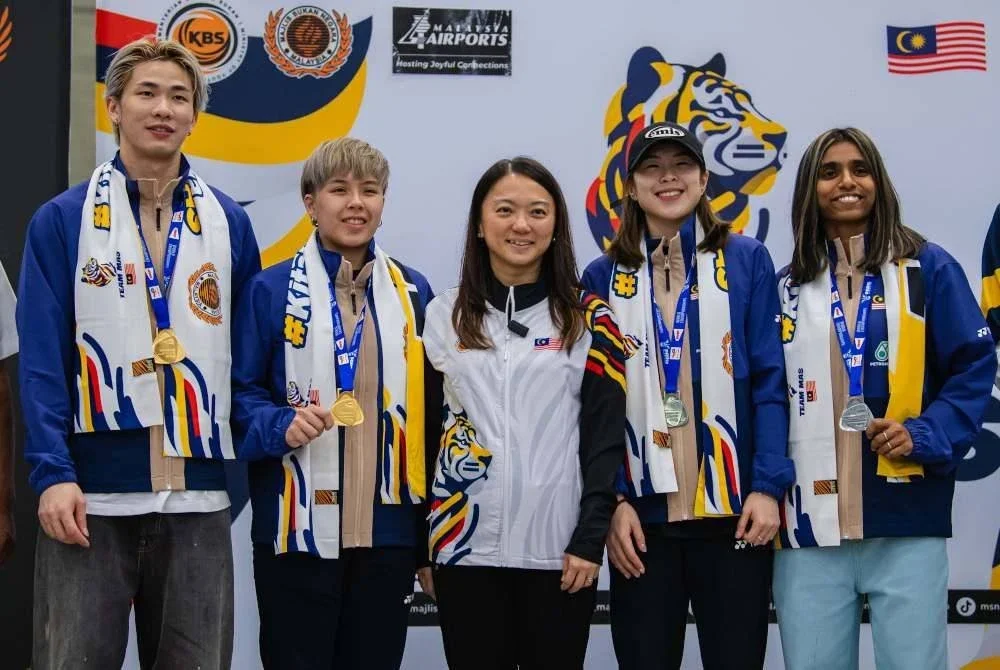 Hannah (tengah) bersama skuad badminton negara yang tiba di KLIA selepas menyertai Kejohanan Dunia 2025 di Paris.