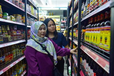 Timbalan Menteri Komunikasi, Teo Nie Ching (kanan) menemani Azmida Kassim membeli barang keperluan asas menggunakan Bantuan Sumbangan Asas Rahmah (SARA) di Pasaraya Chop Lee Kwan hari ini. Foto Bernama