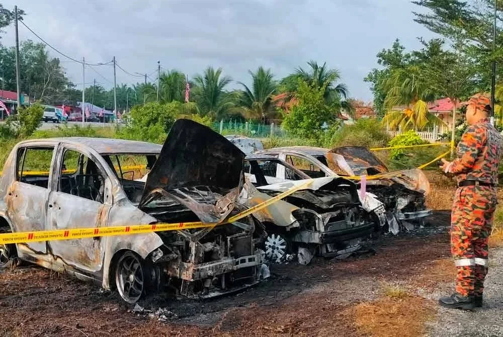 Anggota bomba melihat tiga kenderaan yang terbakar sepenuhnya di Kampung Beringin pada awal pagi Rabu.