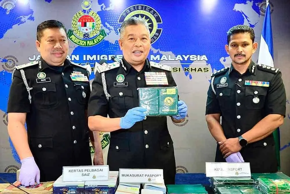 Zakaria (tengah) menunjukkan pasport yang dirampas ketika sidang akhbar pada Rabu.. - FOTO: SINAR HARIAN/ ASRIL ASWANDI SHUKOR