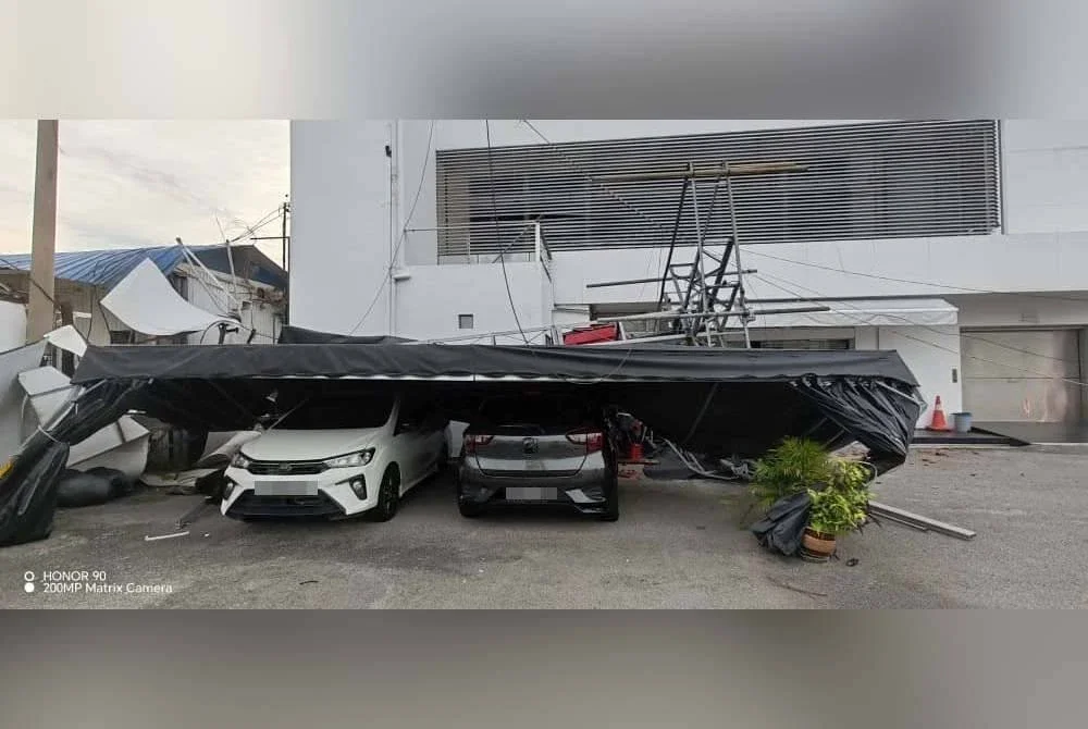 Dua buah kereta rosak dihempap antena telekomunikasi yang tumbang dalam kejadian di Wisma EMC, Jalan Baru, di sini petang Rabu.