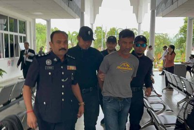 Tertuduh (dua dari kanan) diiringi anggota polis ketika dibawa ke Mahkamah Majistret Bukit Mertajam pada Rabu.