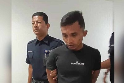 Tertuduh (kanan) ketika dihadapkan di Mahkamah Majistret Kuala Terengganu pada Rabu.