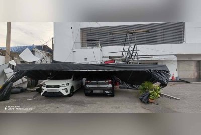 Dua buah kereta rosak dihempap antena telekomunikasi yang tumbang dalam kejadian di Wisma EMC, Jalan Baru, di sini petang Rabu.