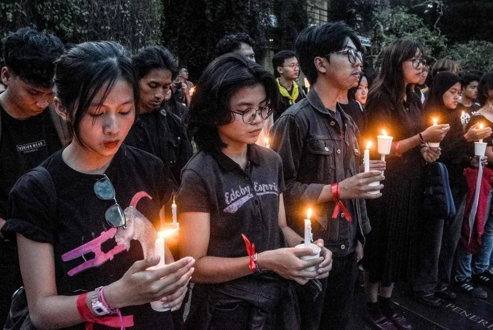 Pelajar memegang lilin di Institut Teknologi Bandung (ITB) di Bandung, Jawa Barat pada 2 September, ketika mereka memberi penghormatan kepada mangsa yang terbunuh dalam pertempuran antara polis dan penunjuk perasaan yang menuntut reformasi polis dan pembubaran Parlimen. Foto AFP