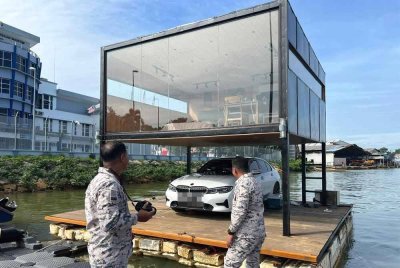 Platform terapung bersama kereta yang digunakan pempengaruh media sosial sebagai lokasi penggambaran yang ditahan Maritim Malaysia berhampiran Pulau Bidong dibawa ke Jeti Maritim Negeri Terengganu pada Khamis. FOTO: Maritim Terengganu