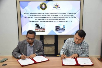 Adi Supian (kiri) ketika Majlis Menandatangani Laporan Penambahbaikan Tatakelola berhubung mekanisme pengurusan kontrak pemasangan struktur papan iklan luar di Melaka di Kompleks CMI baru-baru ini. Foto SPRM 