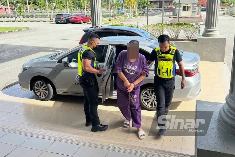 Mudir (tengah) tiba dengan kenderaan polis di Mahkamah Pasir Mas untuk mengambil perintah sambung reman.